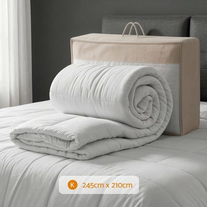 Rolled white wool quilt with thick box-baffle filling, stacked on a bed