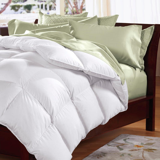 White quilt with two feather pillows on a bed
