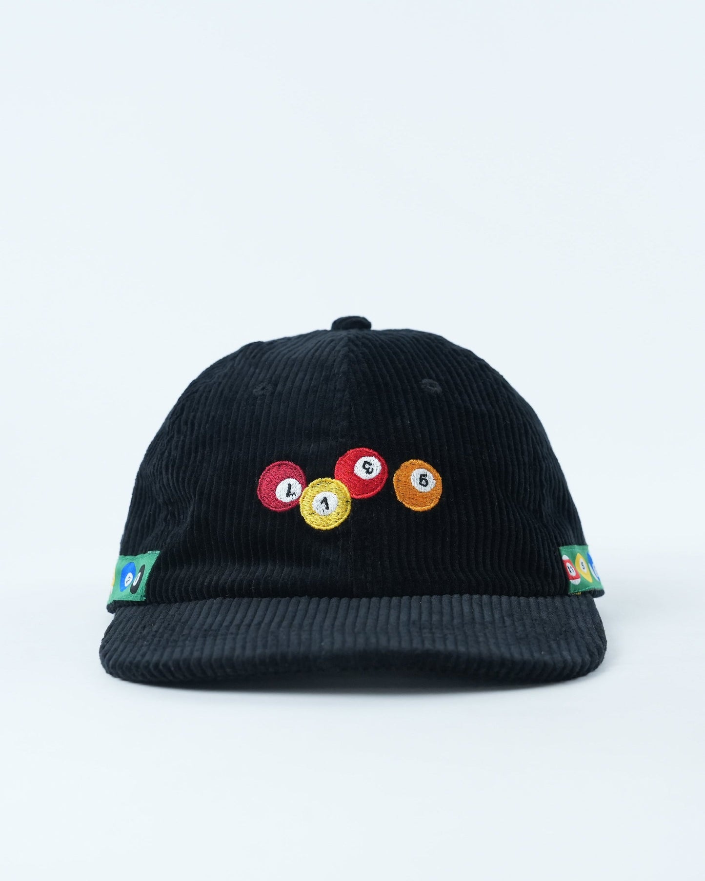 Black corduroy baseball cap with multicolor pool-ball patch on front