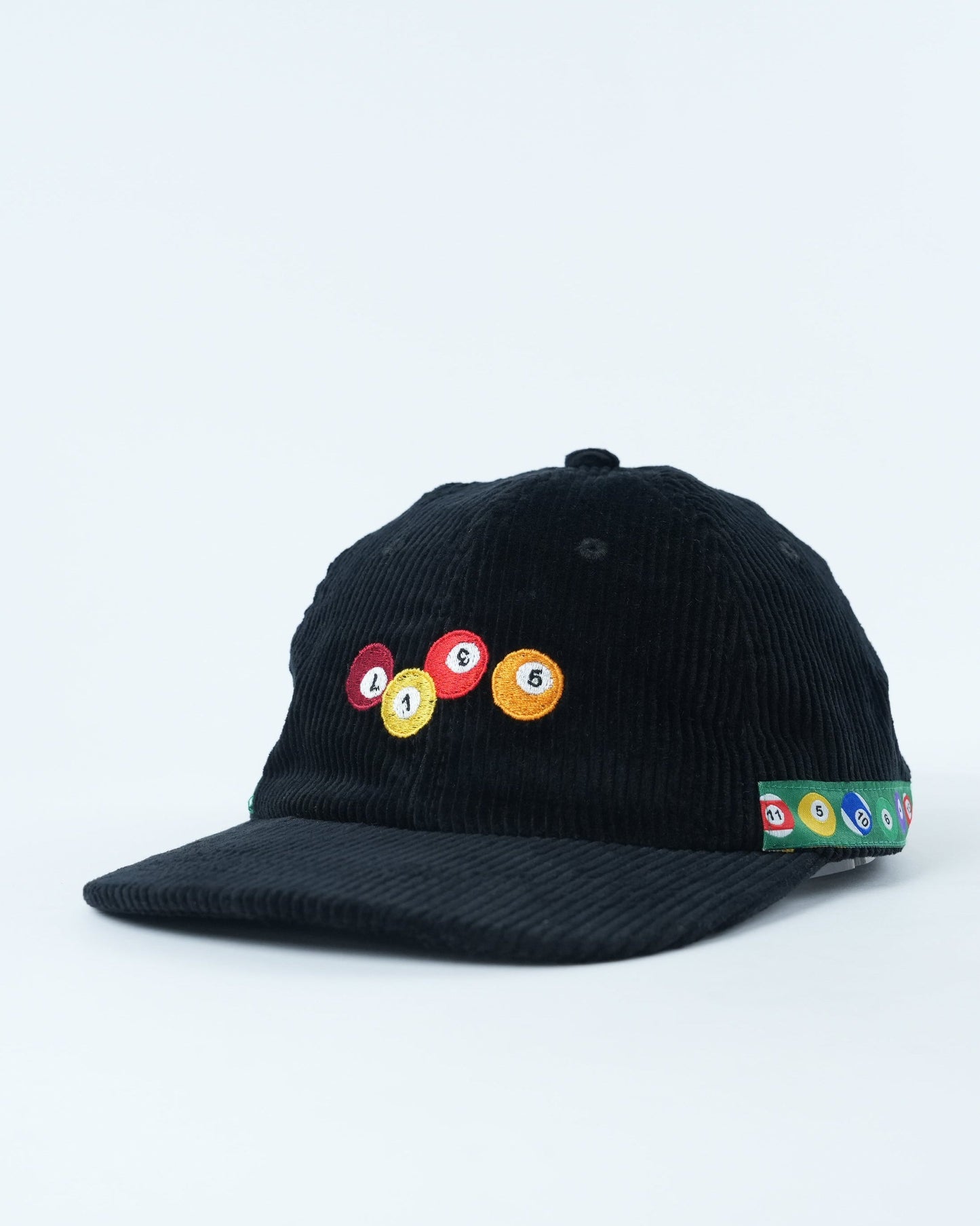 Black corduroy baseball cap with pool-ball patch and multicolor trim along brim