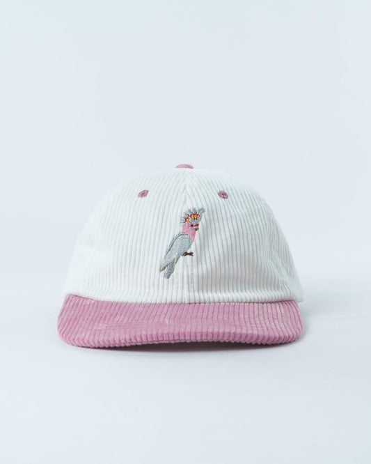 White corduroy-style beanie with pink ribbed brim and embroidered pink cockatoo