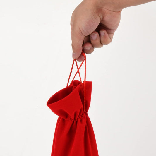 Red velvet bottle gift bag with two drawstrings, held open by a hand