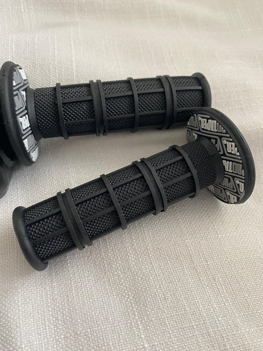 Pair of black textured handlebar grips with end cap and logo badge