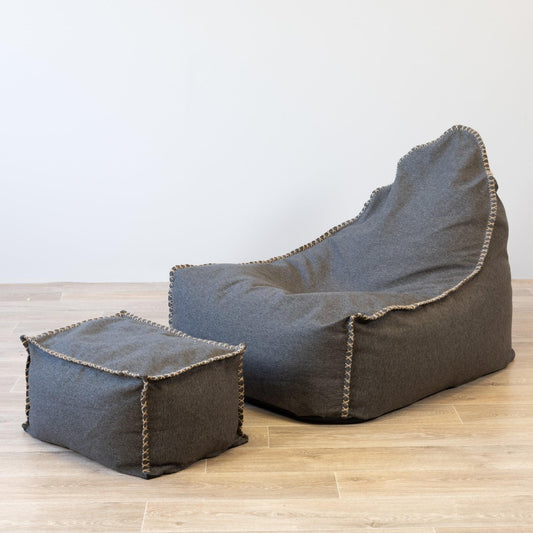 Charcoal fabric bean bag and matching ottoman with stitched trim, side view