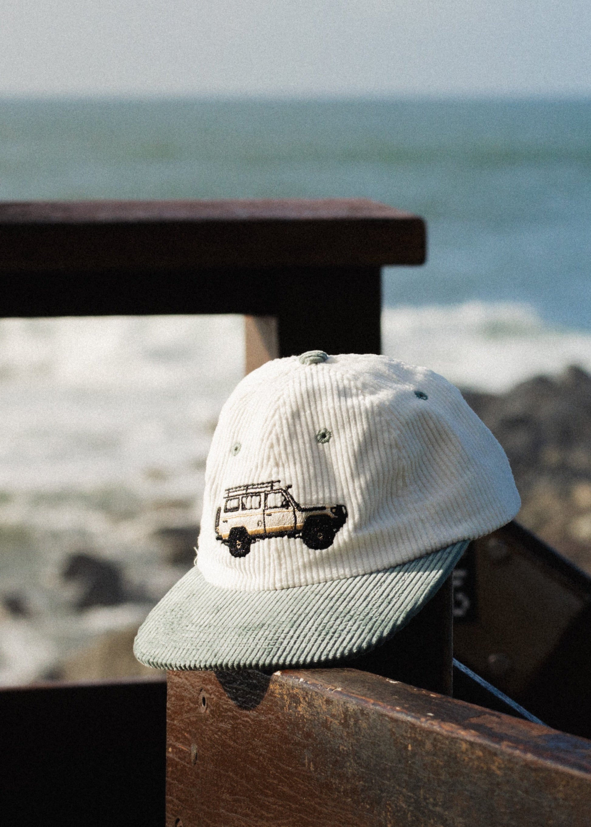 Troopy hat on railing with white crown, teal brim, and truck logo patch.