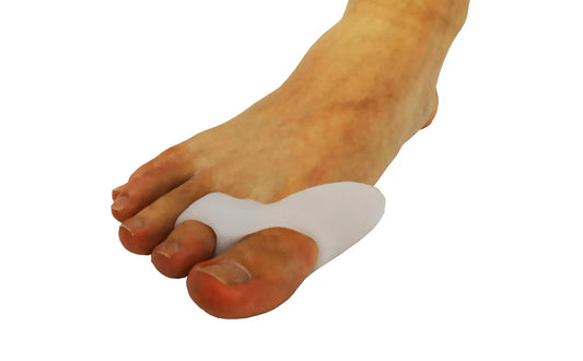 White silicone bunion toe sleeve worn on the foot, covering the big toe area