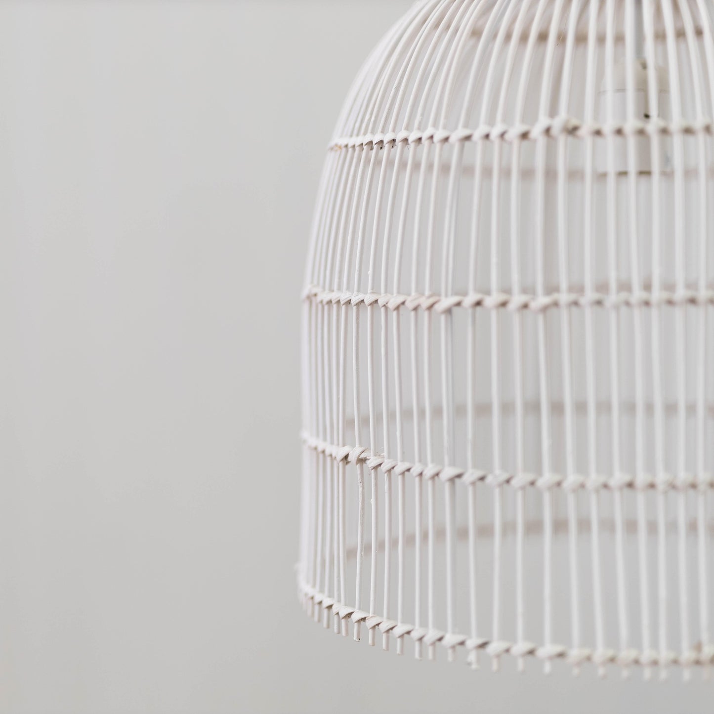 Whitewash rattan cane pendant light side view with horizontal band and scalloped bottom