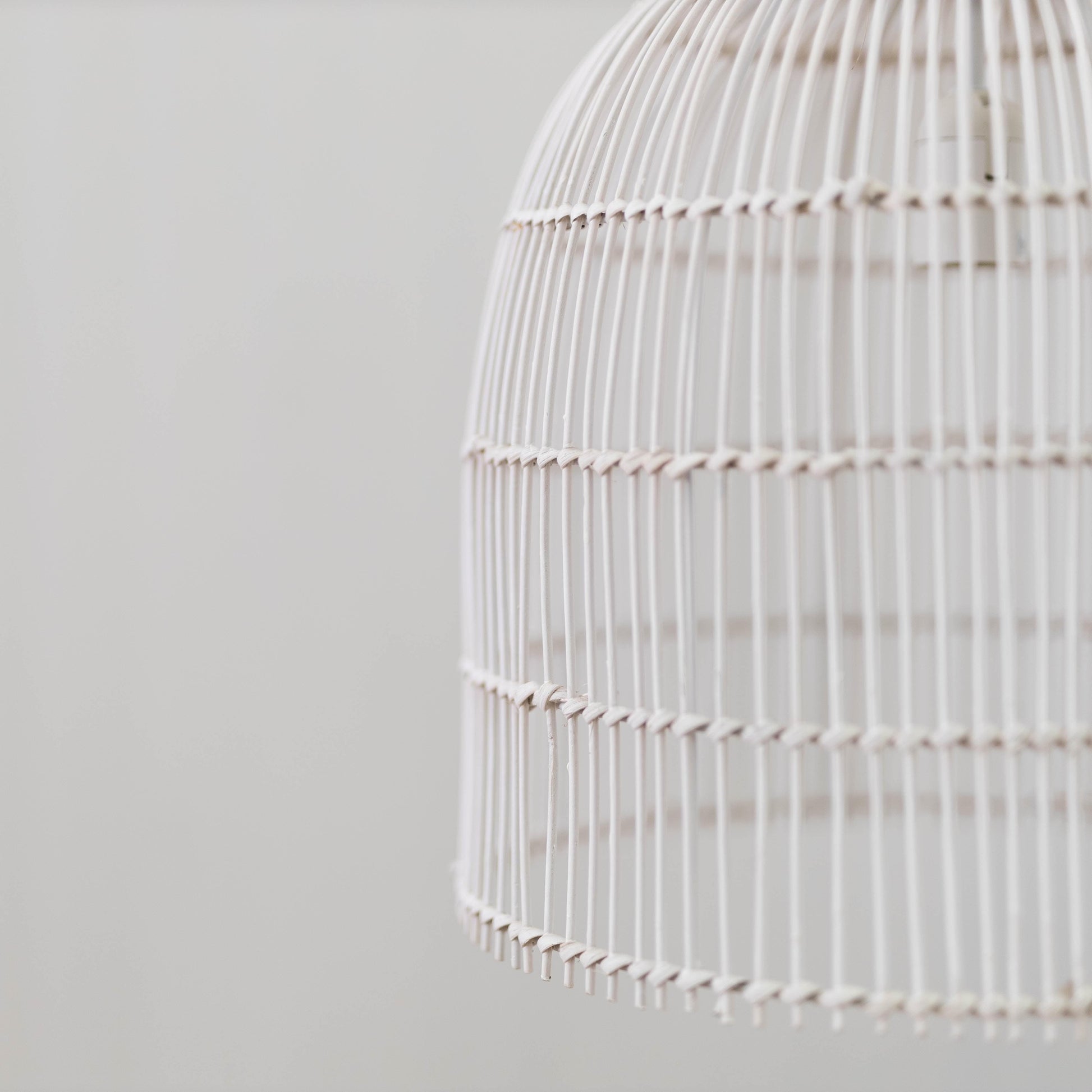 Whitewash rattan cane pendant light side view with horizontal band and scalloped bottom