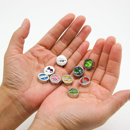 Set of round wearable diffuser lockets with different animal designs held in open hand