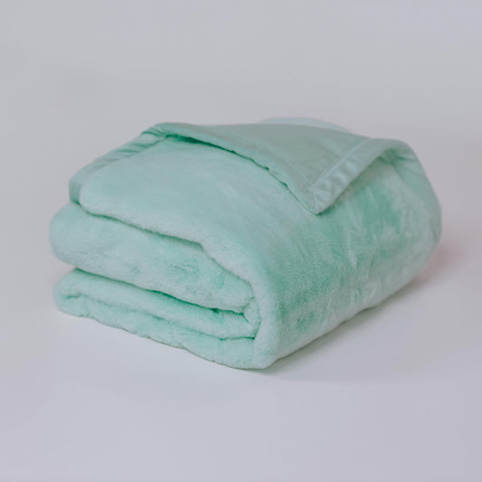 Turquoise plush fur throw blanket, tightly folded with soft fur texture.
