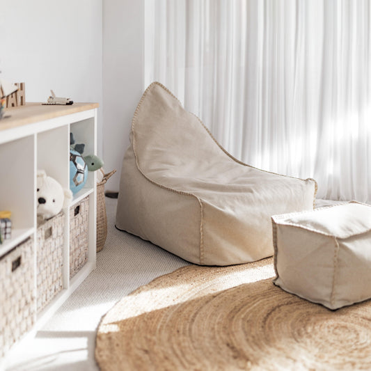 Natural bean bag and ottoman, beige canvas with piped seams and rounded armrest shape