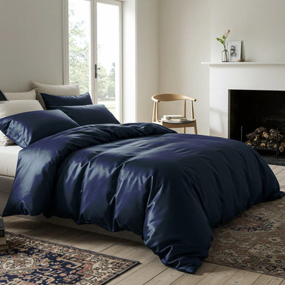 Navy satin quilt cover with glossy, wrinkle-textured duvet cover spread on bed