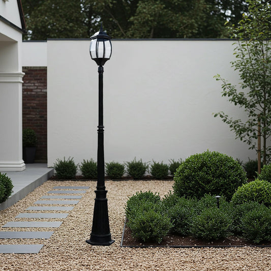 Black Victorian garden lamp post with lantern-style glass shade and finial top.