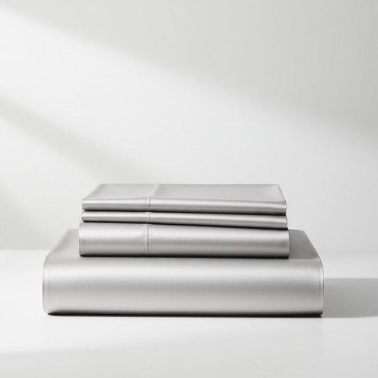 Silver satin sheet set with flat and fitted sheets, neatly stacked in a fold