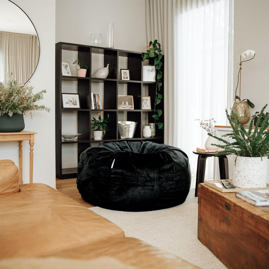 Black round bean bag chair with gathered fabric and rounded, low profile