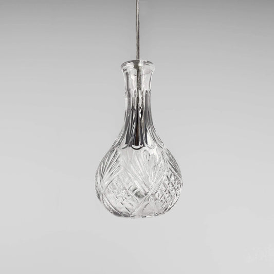 Clear glass decanter-style pendant light with faceted body and chrome stem