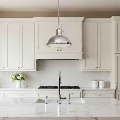 Chrome metal pendant light with domed shade above white kitchen cabinets