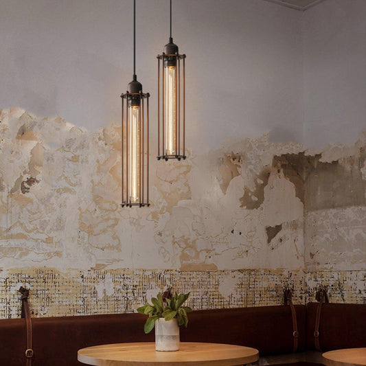 Pair of black industrial pendant lights with brass tops and tall glass tube shades