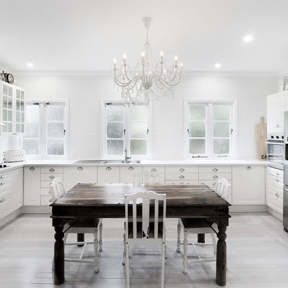 Cassie 12-light crystal chandelier hanging over a dining table, with clear glass drops