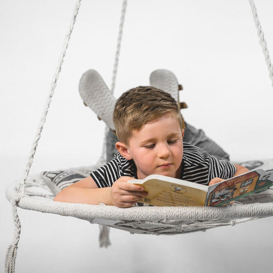 Cream macrame hanging hammock swing with round woven seat and fringe cords