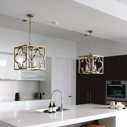 Two gold box frame lantern pendant lights over kitchen island with lit candle bulbs