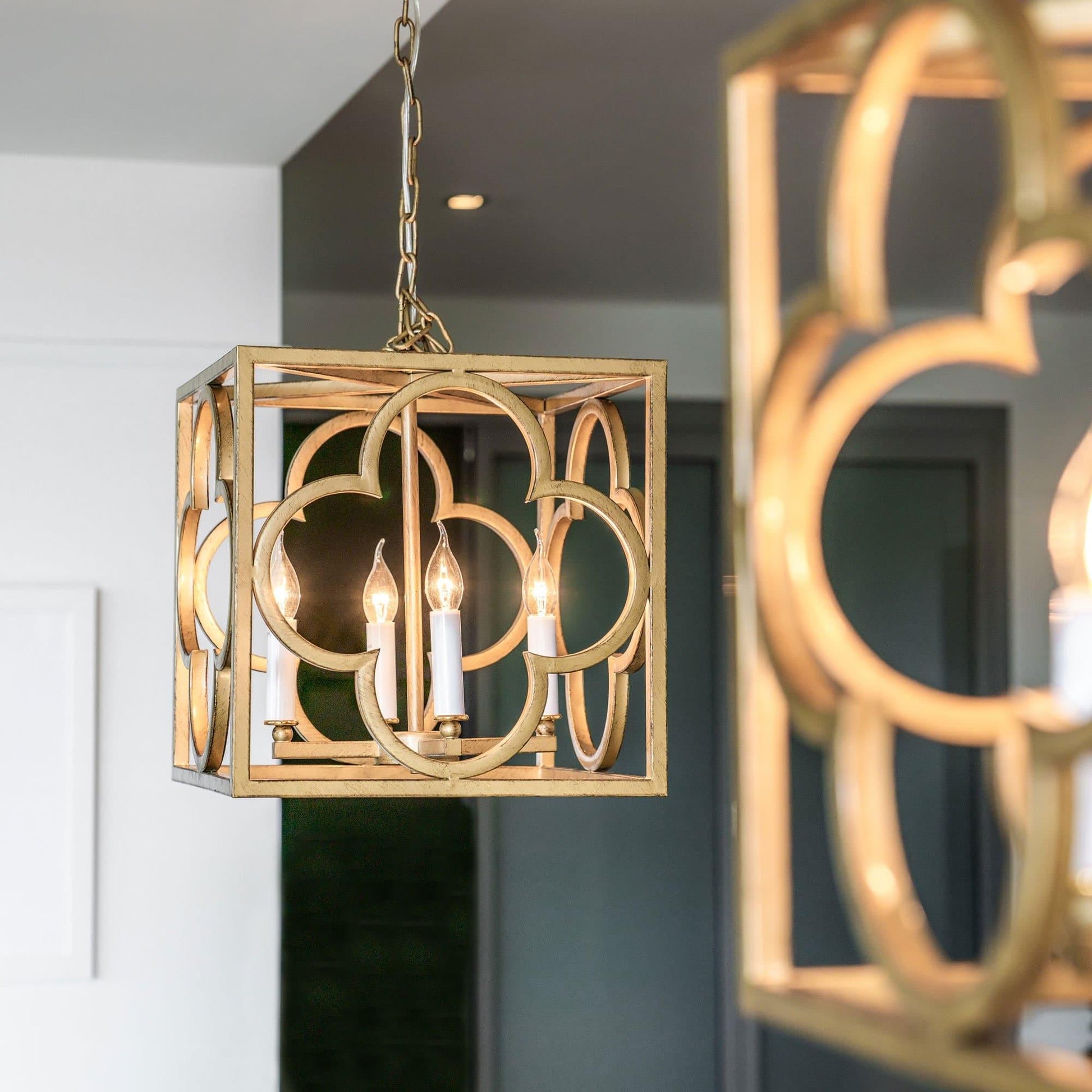 Gold lantern pendant light with box frame and arched circular detailing on hanging chain