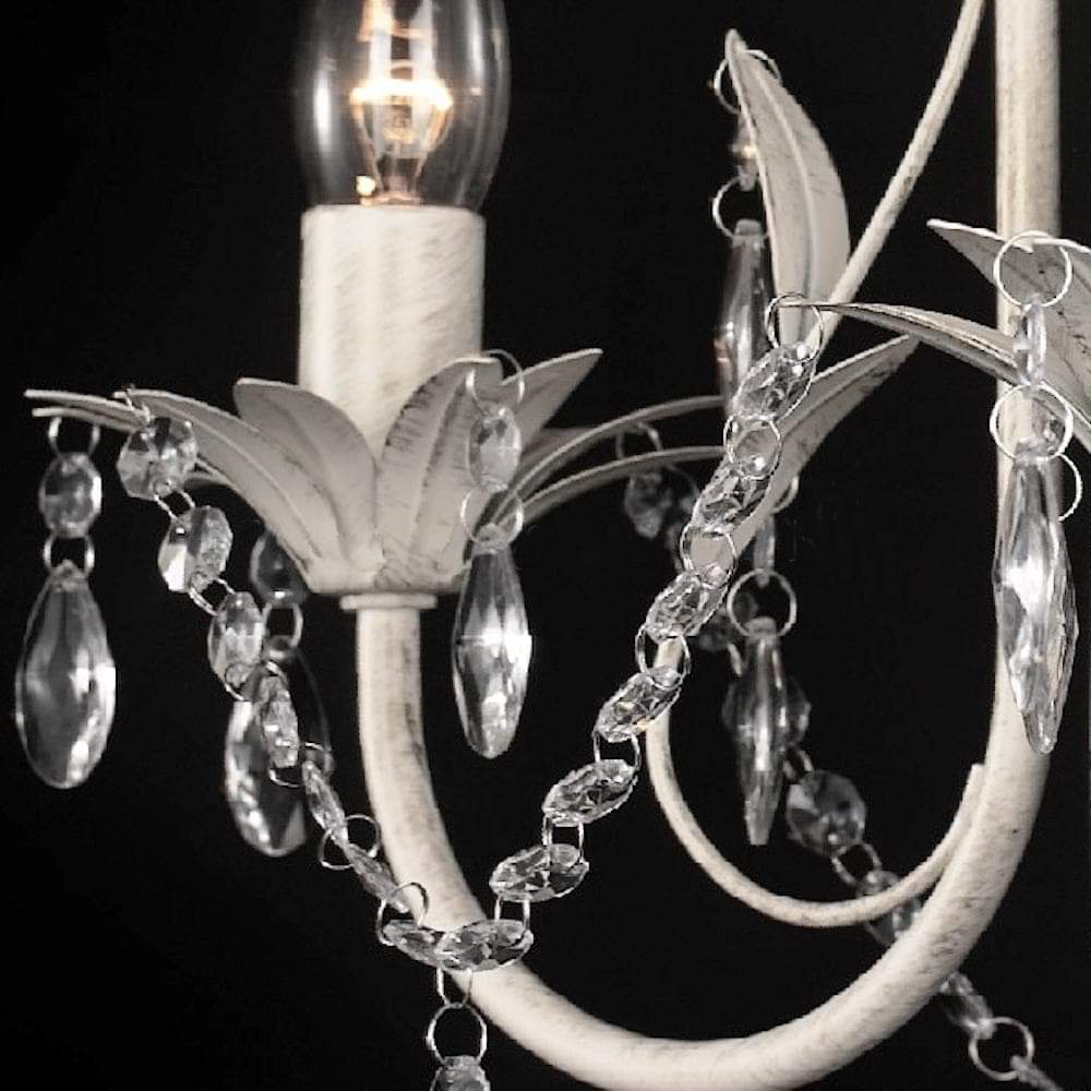 White leaf chandelier close-up with crystal teardrop drops and candle bulb