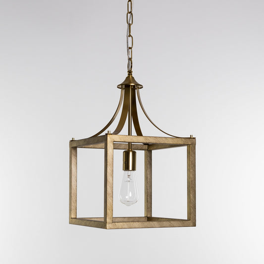 Brushed gold lantern pendant light with glass panels and clear bulb inside metal frame