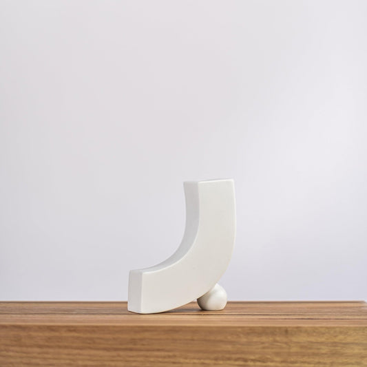 White ceramic blossom vase with curved crescent form and small sphere base