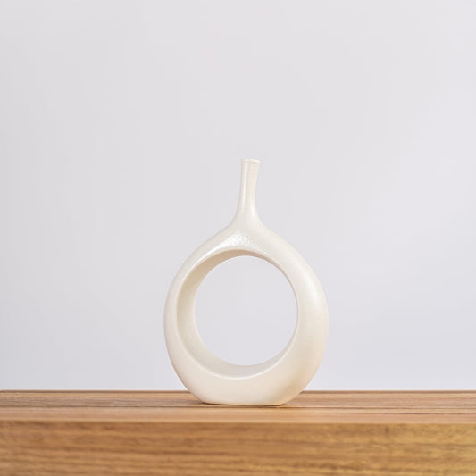 Cream ceramic vase with circular ring cutout and narrow neck, teardrop body