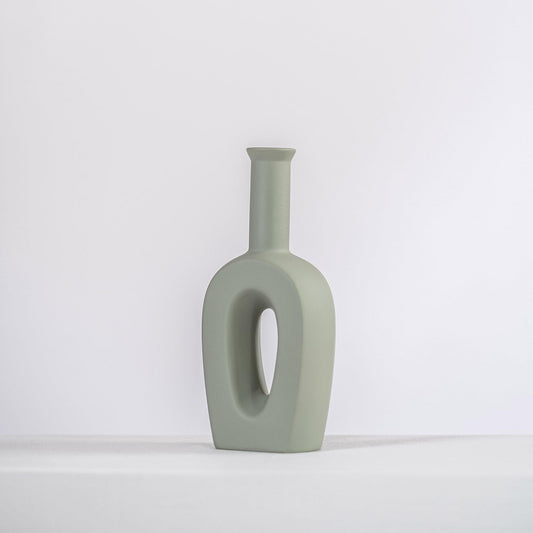 Sage grey ceramic tulip vase with oval cutout, minimalist form.