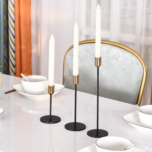 Black metal candlestick set with three taper holders, round bases, and brass tops