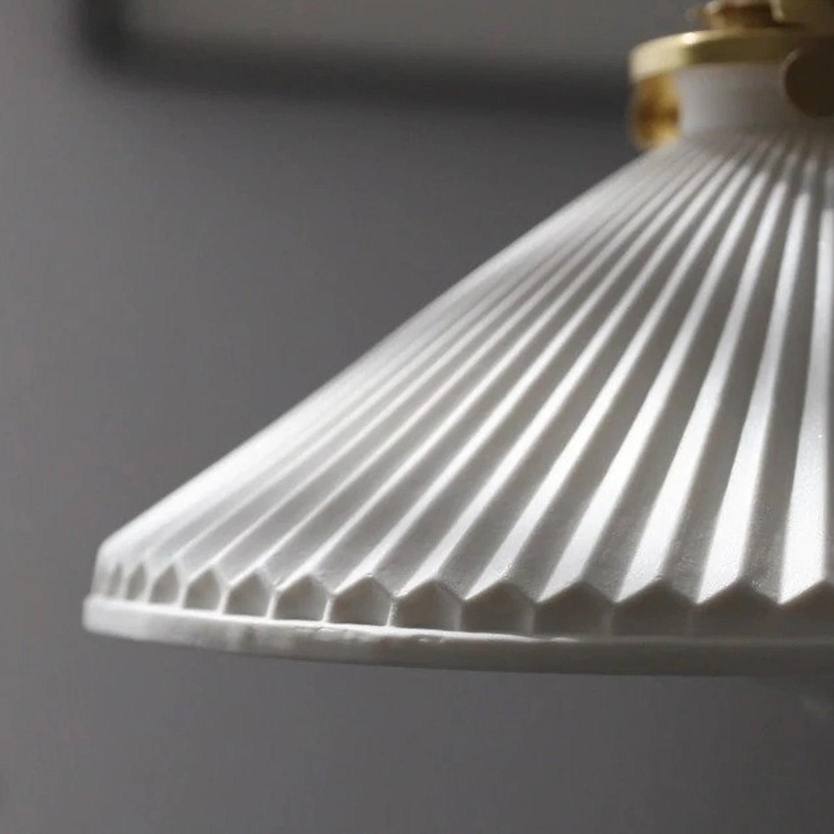 Close-up of white ceramic pleated shade texture on brass pendant light