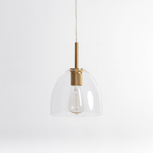 Gold pendant light with clear glass bell shade and brass top, hanging on cord