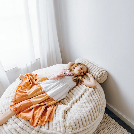 Cream channel-cord lounger with curved backrest, shown with sleeper