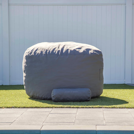 Grey bean bag chair with folded top cover and front storage pocket