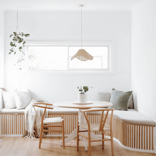 Rattan pendant light hanging over dining table, woven wavy shade