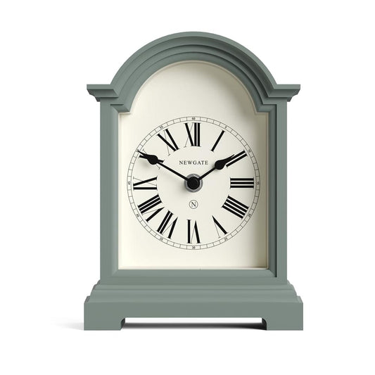 Asparagus green mantel clock with roman numerals and black hands, arched glass frame.