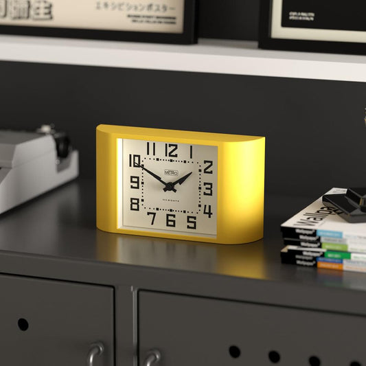 Yellow mantel clock with white face, black numerals, and black hands