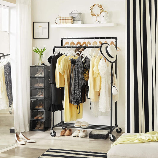 Clothes rack with wheels, dark pipe frame, hanging shirts and coats, lower shelf with shoes