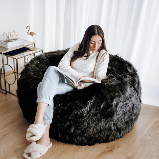 Black faux-fur bean bag with thick shag pile, used for lounging