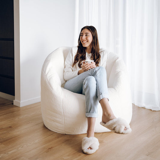 Ivory ribbed corduroy tub chair bean bag cover, person seated in rounded cushion