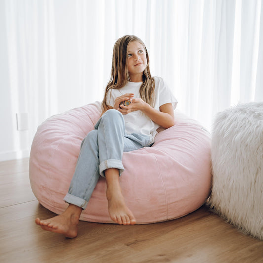Blush pink cushioned bean bag lounger with soft, rounded cover