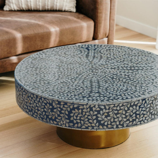 Round coffee table top with blue mother-of-pearl inlay leaf pattern and brass base