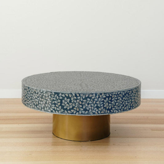 Round coffee table with blue mother-of-pearl inlay pattern and brass base