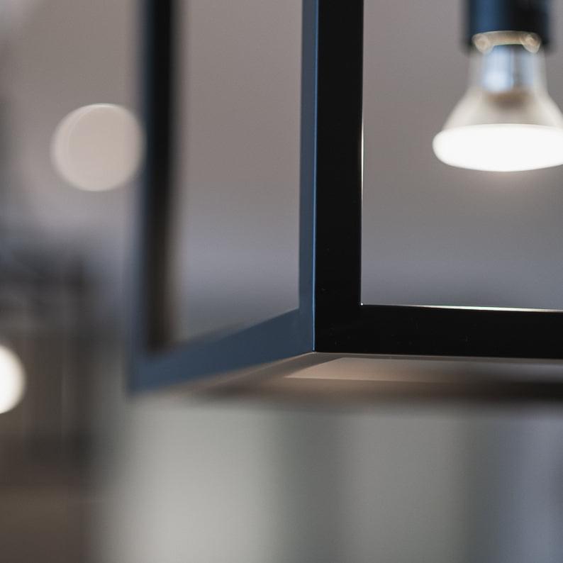 Black lantern pendant light close-up of metal frame and hanging chain