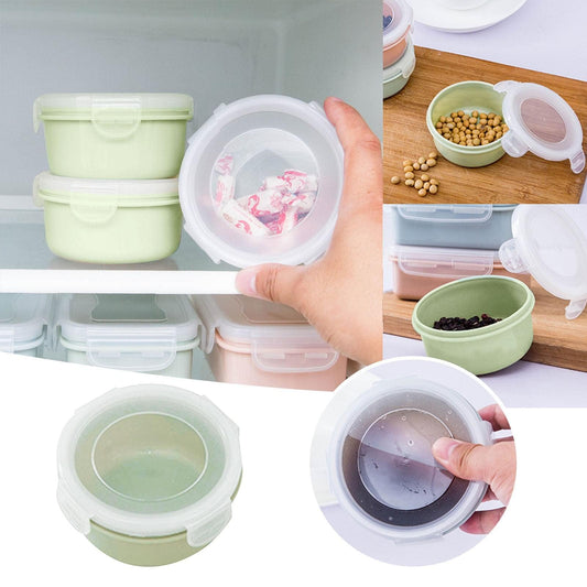 Stacked small plastic storage containers with snap lids, pale green and clear