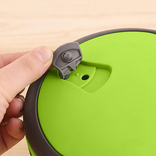 Green lunch container lid handle latch detail with gray locking piece
