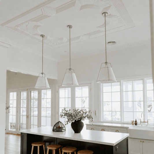 White bell pendant lights with nickel hardware, multiple shades.