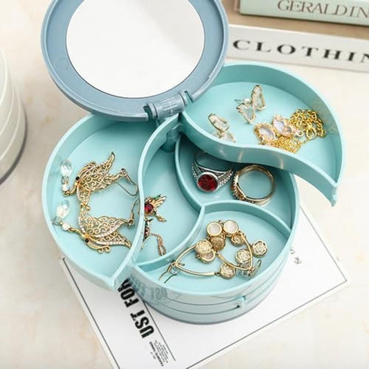 Light blue rotating jewelry box open to show earrings and rings in sections